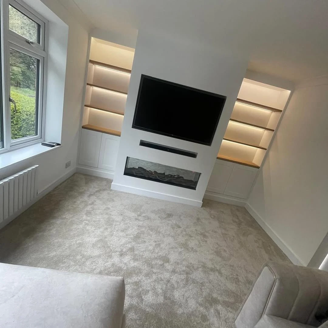 Living room with recessed downlights and backlit alcove shelving