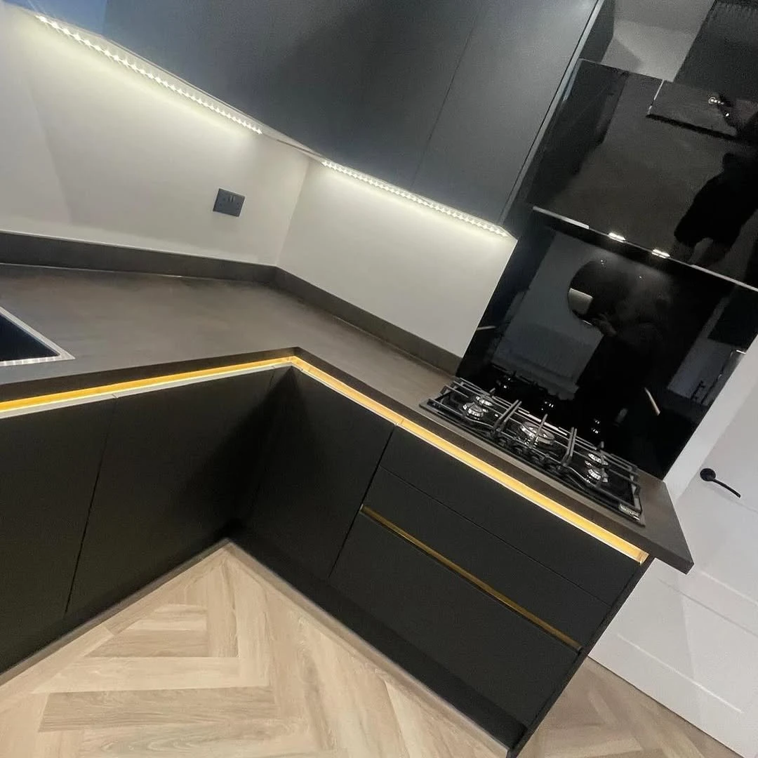 Dark kitchen units with LED plinth and under-cabinet lighting